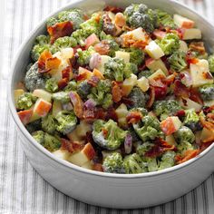 a white bowl filled with broccoli and other vegetables on top of a table