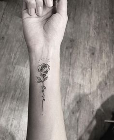 a small rose tattoo on the wrist is shown in black and white, with text below it