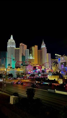 the las vegas skyline is lit up at night with neon lights and buildings in the background