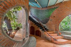 the inside of a brick house with stairs and circular mirrors on the wall above it