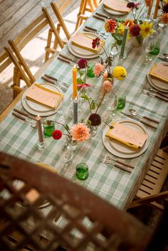 the table is set with place settings and flowers