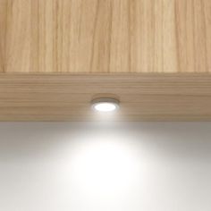 a close up of a light on a wooden surface with wood grained material behind it