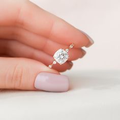 a woman's hand holding a diamond ring