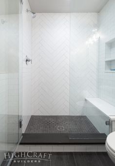 a bathroom with a walk in shower next to a toilet