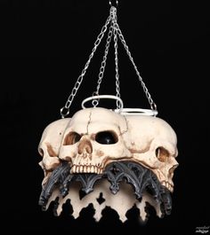 a skull hanging from a chain on a black background