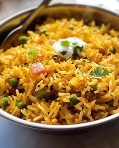 a bowl filled with yellow rice and peas