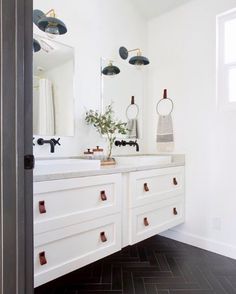 a bathroom with two sinks and mirrors in it