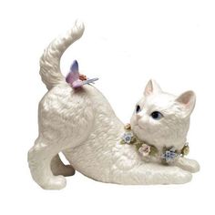 a white cat figurine with a butterfly on it's back sitting down