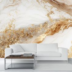 a white couch sitting in front of a wall with gold paint on it's walls