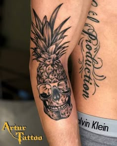 a couple of people with tattoos on their arms and legs, one has a skull in the shape of a pineapple