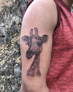 a giraffe tattoo on the arm of a man's left arm and shoulder