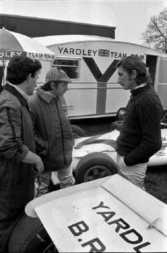 three men are standing in front of a van with the word yardley's team on it