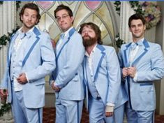 four men in blue suits posing for a photo