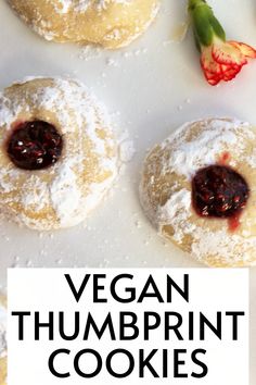 vegan thumbprint cookies with powdered sugar and jam on top, surrounded by fresh flowers