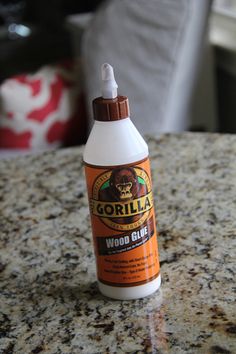 a bottle of gorilla wood glue sitting on top of a granite countertop next to a chair