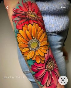 a woman's arm with flowers painted on it and an orange flower in the center