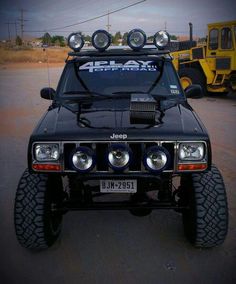 the front end of a black jeep with lights on