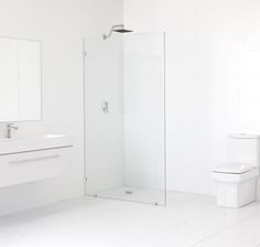 a bathroom with a toilet, sink and shower stall is shown in white tiles on the floor