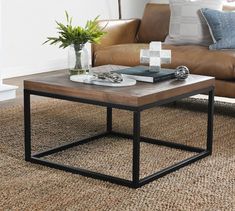 a coffee table sitting on top of a rug in front of a brown leather couch