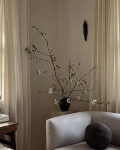 a living room with a white couch and flowers in a vase