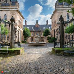 an old building with a fountain in the middle of it's courtyard, surrounded by wrought iron gates