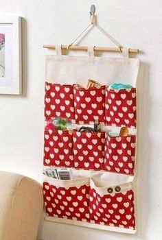 a red and white heart pattern hanging on a wall next to a chair with a magazine holder