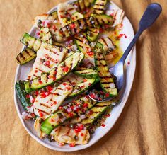 grilled vegetables on a plate with a spoon