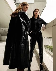 two women standing next to each other on a balcony