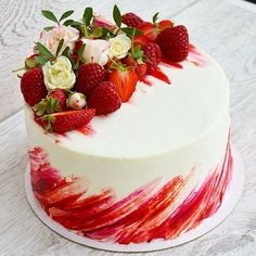 a white cake decorated with strawberries and roses