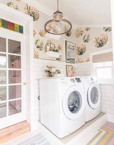 there is a washer and dryer in the room with flowers on the wall