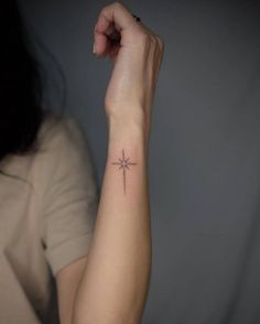 a woman's arm with a small star tattoo on the left side of her arm