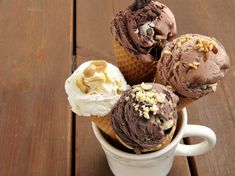 three scoops of gelato with nuts and chocolate ice cream in a white cup