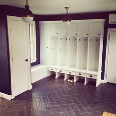 an empty room with several white lockers and two lamps hanging from the ceiling above them