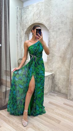 a woman in a green dress taking a selfie