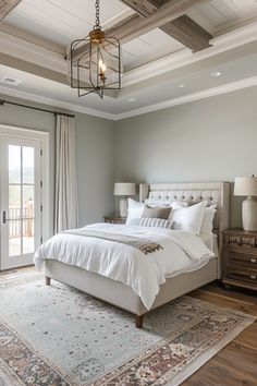 a bedroom with a large bed and two lamps on either side of the bed, in front of a sliding glass door