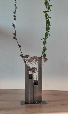 two vases with plants in them sitting on a table