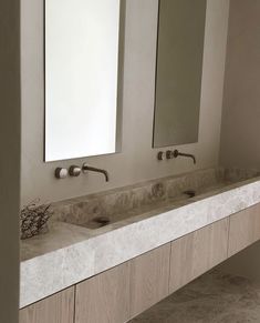 two sinks in a bathroom with mirrors above them