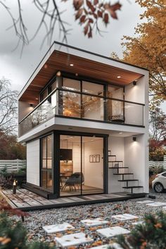 a small house with stairs leading up to the top floor and an open porch area