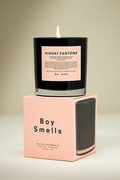 a candle that is sitting on top of a box with the words boy smells printed on it