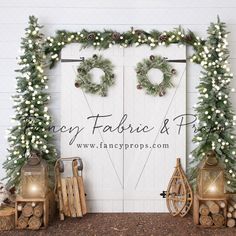 two christmas wreaths are hanging on a white door with greenery and lights around it