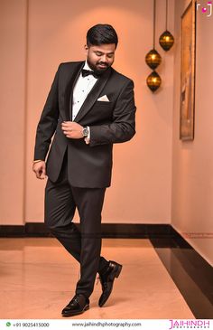 a man in a tuxedo is posing for the camera with his hand on his hip