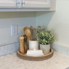 a kitchen counter topped with pots and wooden utensils