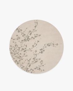 a round rug with flowers on it in beige and grey colors, against a white background