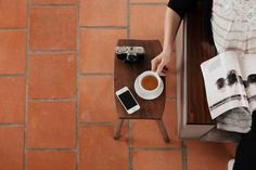 a person sitting at a table with a cup of coffee and cell phone on it