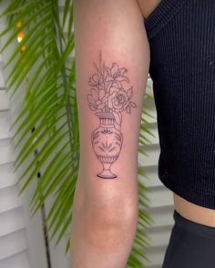 a woman with a flower vase tattoo on her arm