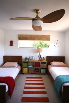 a bedroom with two twin beds and a rug on the floor in front of them