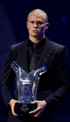 a man in a suit holding an award