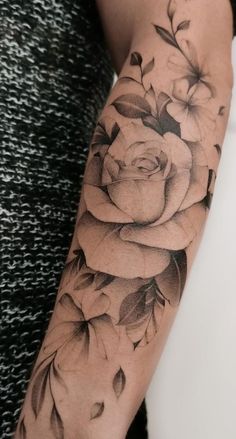 a black and white rose tattoo on the arm