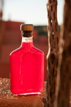 a red bottle sitting on top of a wooden table