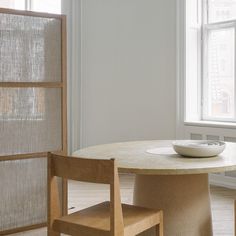 a white bowl sitting on top of a table next to two chairs and a window